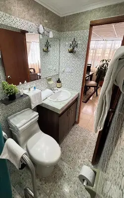 a bathroom with a toilet and a sink and a mirror at Casa Boutique Familia Hurtado in Manizales