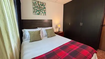 a bedroom with a bed with a plaid blanket at Casa Boutique Familia Hurtado in Manizales