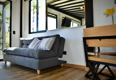 a couch in a living room with two mirrors at Cabaña del lago con Jacuzzi in Rionegro