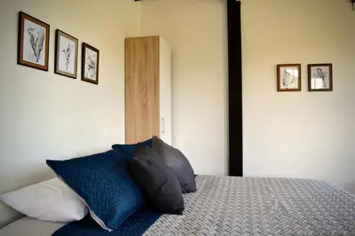 a bedroom with a bed with blue pillows on it at Cabaña del lago con Jacuzzi in Rionegro