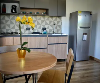 a kitchen with a table with a yellow flower on it at Cabaña del lago con Jacuzzi in Rionegro