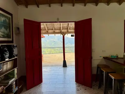 an open red door with a view of a mountain at Finca cafetera para descanso in Fredonia