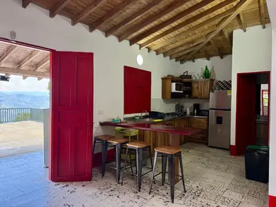 a kitchen with red cabinets and a table and stools at Finca cafetera para descanso in Fredonia
