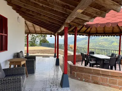a patio with a table and chairs and a view at Finca cafetera para descanso in Fredonia