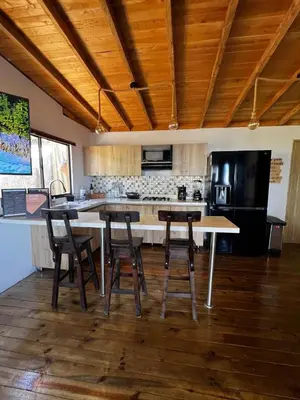 a kitchen with a table and stools in a room at Cabaña El Sueño de OPAD in Guarne