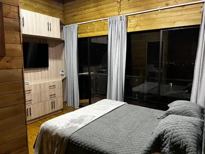 a bedroom with a bed and a large window at Cabaña El Sueño de OPAD in Guarne