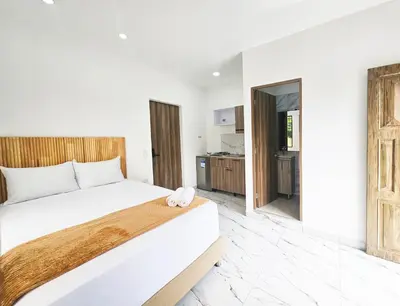 a bedroom with a large bed and a kitchen at Casa Eterna Campo Valdes in Medellín