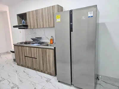 a kitchen with a stainless steel refrigerator and a sink at Casa Eterna Campo Valdes in Medellín