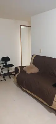 a bed in a room with a mirror and a chair at Central apartment with air conditioning in Medellín