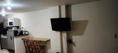 a tv on the corner of a room with a kitchen at Central apartment with air conditioning in Medellín