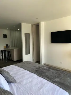 a bedroom with a bed with a flat screen tv on the wall at Class 48 Exclusivo y elegante apartamento in Sabaneta