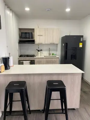 a kitchen with a large counter with two stools at Class 48 Exclusivo y elegante apartamento in Sabaneta