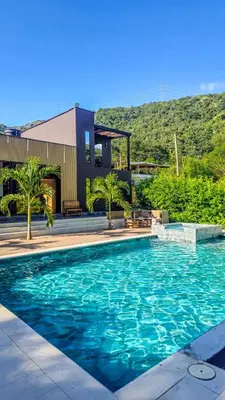 a swimming pool in front of a house at La Fonte di Luce in Santa Fe de Antioquia