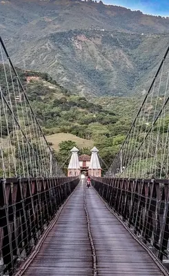 a bridge over a mountain with a person on it at La Fonte di Luce in Santa Fe de Antioquia