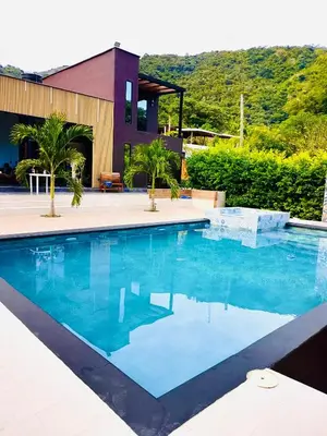 a swimming pool in front of a house at La Fonte di Luce in Santa Fe de Antioquia