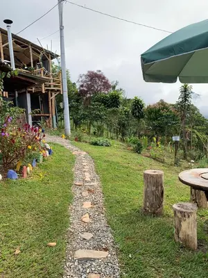 a stone path in the grass next to a building at Finca Crucytania in Titiribí