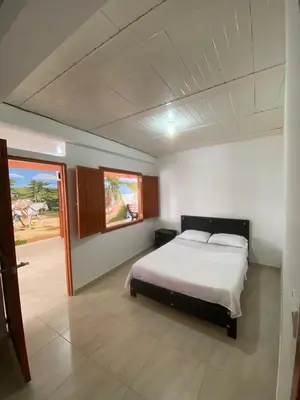 a bedroom with a white bed and a window at Hotel Marquez in Norcasia