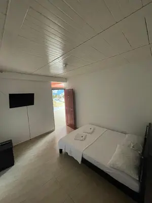 a white room with a bed and a tv at Hotel Marquez in Norcasia