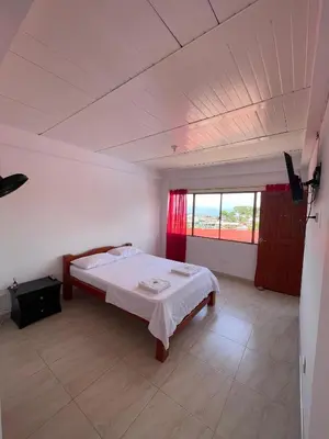 a bedroom with a bed in a room with a window at Hotel Marquez in Norcasia