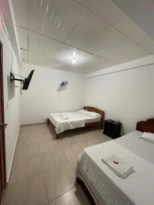 a room with two beds and a tv in it at Hotel Marquez in Norcasia