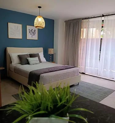 a bedroom with a bed and a large window at Acogedor Apartaestudio en Laureles in Medellín