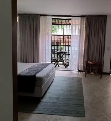a bedroom with a bed and a balcony with a table at Acogedor Apartaestudio en Laureles in Medellín