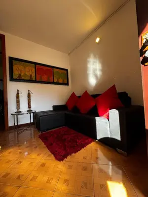 a living room with a black couch and red pillows at Apartamento Hayalón in Betania