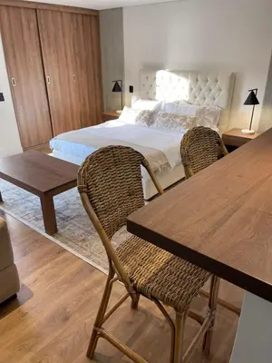 a bedroom with a bed and two chairs and a table at Loft poblado con parqueadero in Medellín