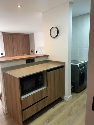 a kitchen with a microwave and a clock on the wall at Loft poblado con parqueadero in Medellín
