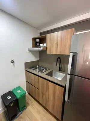 a small kitchen with a sink and a refrigerator at Loft poblado con parqueadero in Medellín