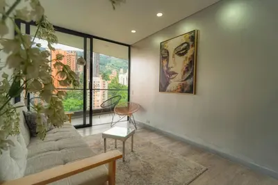 a living room with a couch and a painting on the wall at CLASS Suites in Medellín