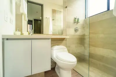 a bathroom with a toilet and a sink and a shower at CLASS Suites in Medellín