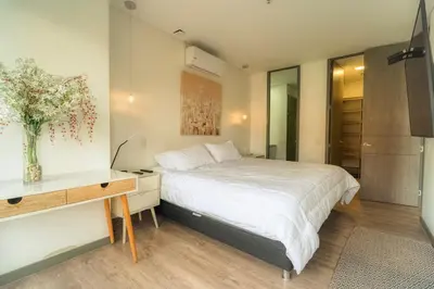 a bedroom with a bed and a desk with a vase of flowers at CLASS Suites in Medellín