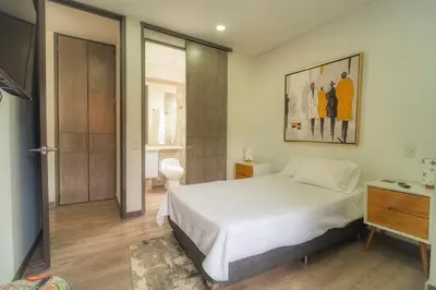 a bedroom with a bed and a bathroom at CLASS Suites in Medellín
