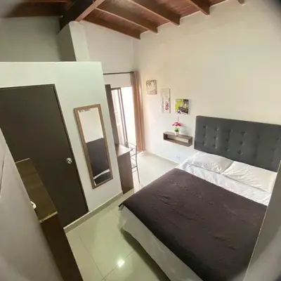 a bedroom with a large bed and a mirror at COMODOS APARTAMENTOS EN LA MEJOR ZONA DE MEDELLIN LAURELES ESTADiO in Medellín