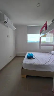 a white bedroom with a bed with a window at Relájate y Disfruta, Apartamento con Piscina, Tobogán y Vista Espectacular en Santa Fé de Antioquia in Santa Fe de Antioquia