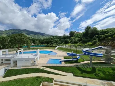 a large swimming pool with slides in a yard at Relájate y Disfruta, Apartamento con Piscina, Tobogán y Vista Espectacular en Santa Fé de Antioquia in Santa Fe de Antioquia