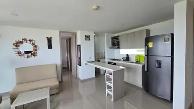 a kitchen with a refrigerator and a table and a counter at Relájate y Disfruta, Apartamento con Piscina, Tobogán y Vista Espectacular en Santa Fé de Antioquia in Santa Fe de Antioquia