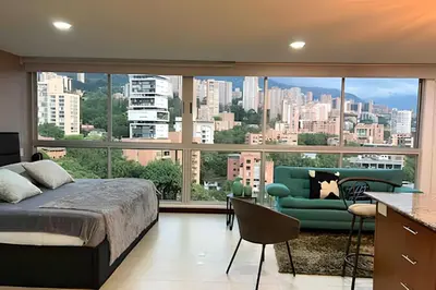 a bedroom with a bed and a large window at Exclusive apto in Poblado in Medellín