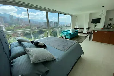 a bedroom with a bed and a large window at Exclusive apto in Poblado in Medellín