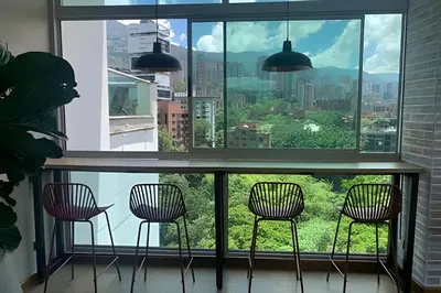 a room with three chairs and a large window at Exclusive apto in Poblado in Medellín