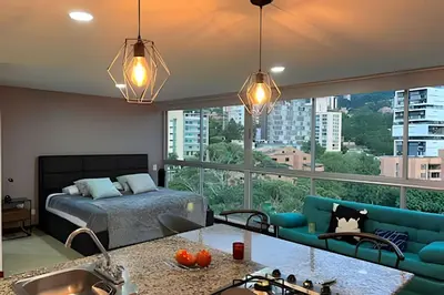 a bedroom with a bed and a large window at Exclusive apto in Poblado in Medellín