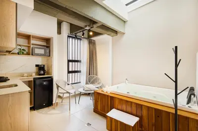 a kitchen with a tub and a table and chairs at Hotel Attic 33 in Medellín