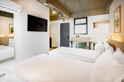 a hotel room with two beds and a desk at Hotel Attic 33 in Medellín