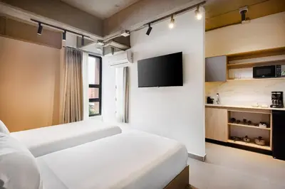 a hotel room with two beds and a tv at Hotel Attic 33 in Medellín