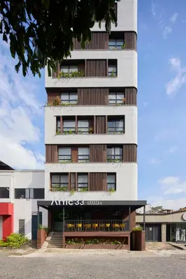 a tall white building with a sign on it at Hotel Attic 33 in Medellín