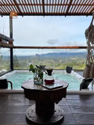 a table with a drink on it in front of a window at Glamping Montesereno in El Peñol