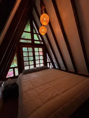 a bedroom with a bed in a room with windows at Glamping Montesereno in El Peñol