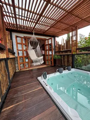 a patio with a hammock and a hot tub at Glamping Montesereno in El Peñol