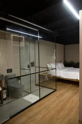 a room with a bed and a glass wall at Hotel Casa Leon Rooftop in Rionegro
